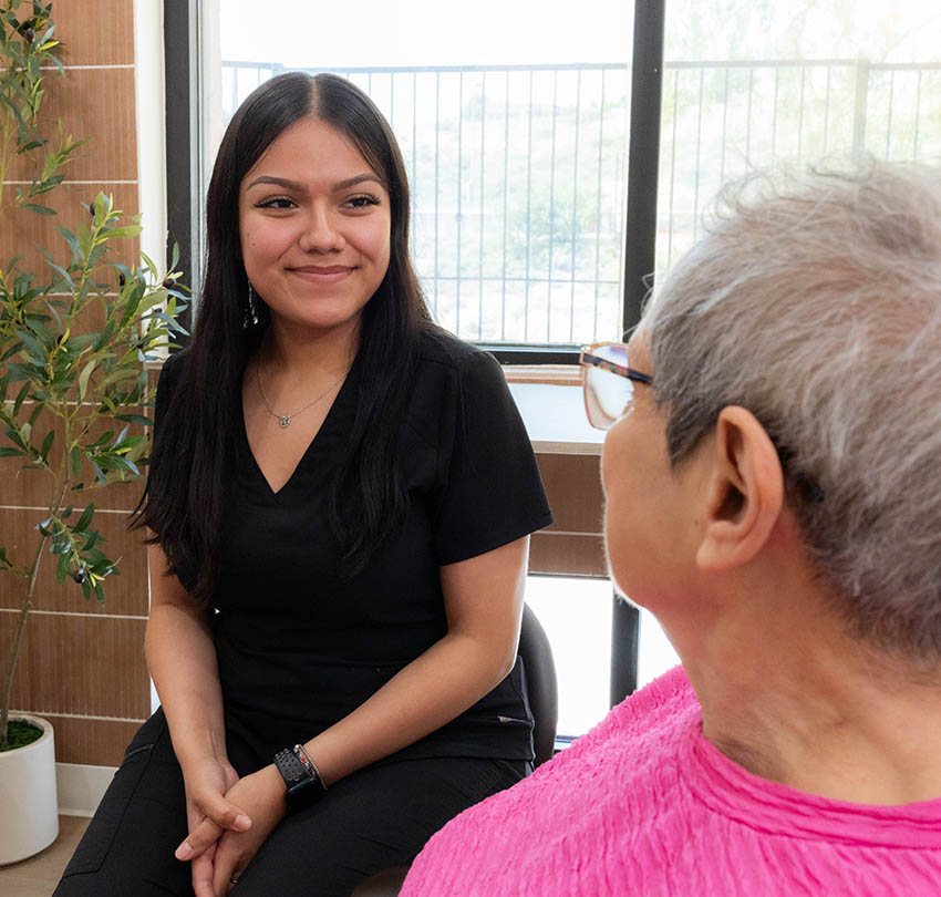 Dental team member speaking with a seated patient